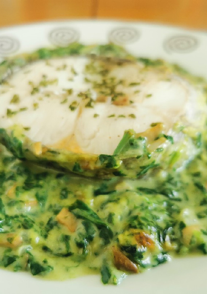 Una foto de Merluza al horno sobre bechamel de espinacas y champiñones
