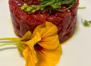Foto di Tartare di scottona al coltello con fiori di nasturzio e senape