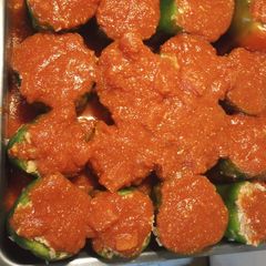 A picture of Stuffed Bell Peppers in a Red Sauce.