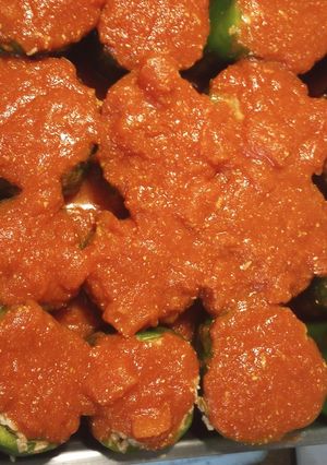 A picture of Stuffed Bell Peppers in a Red Sauce.