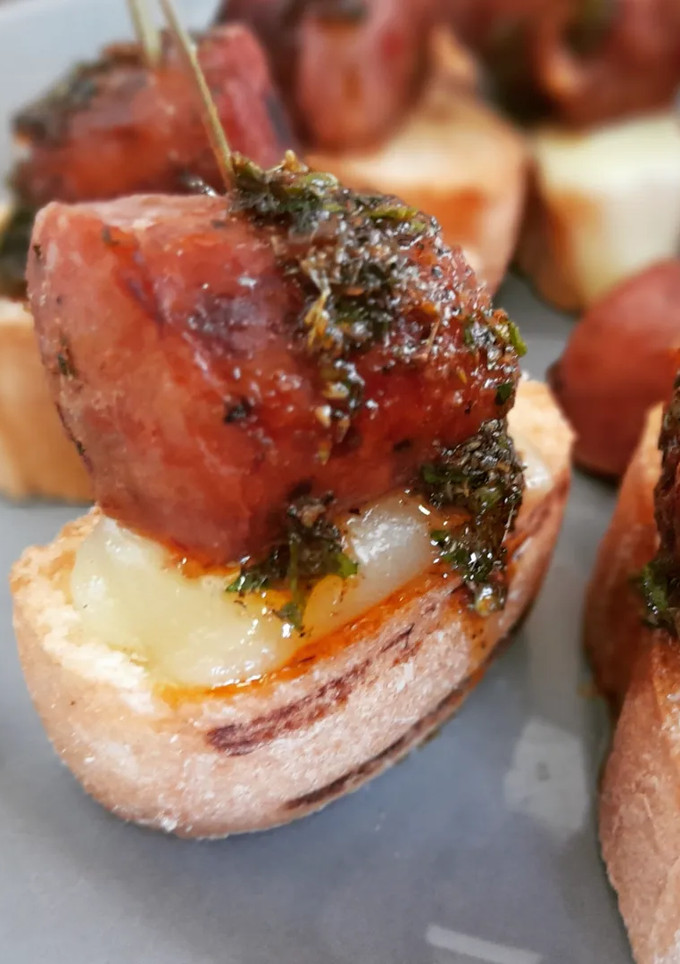 Una foto de Choripan en pincho con provolone y chimichurri