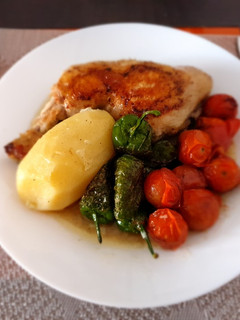 Una foto de Pollo hervido con guarnición de pimientos del padrón y tomatitos