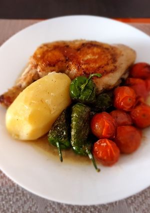 Una foto de Pollo hervido con guarnición de pimientos del padrón y tomatitos