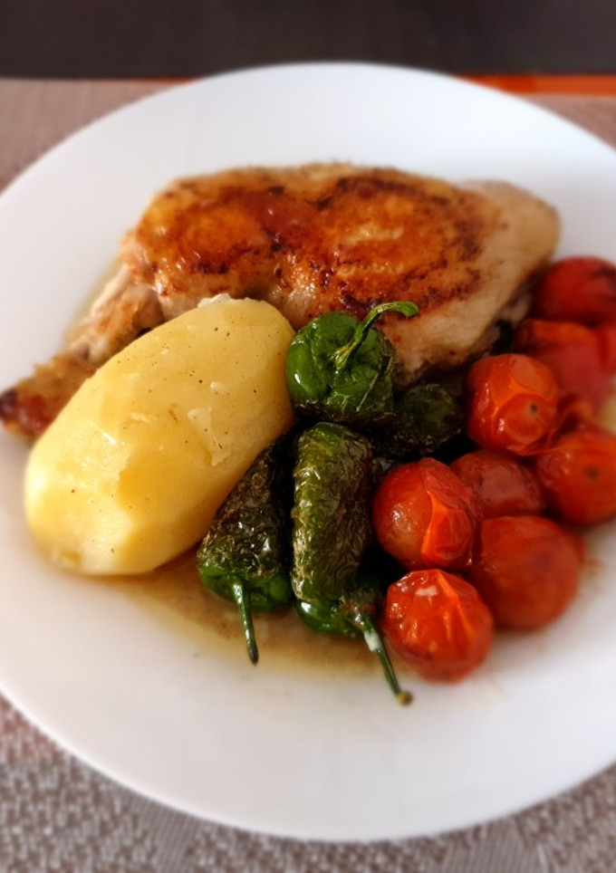 Una foto de Pollo hervido con guarnición de pimientos del padrón y tomatitos