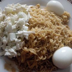 A picture of Jollof noodles, egg and kukunba/ cabbage in cream.