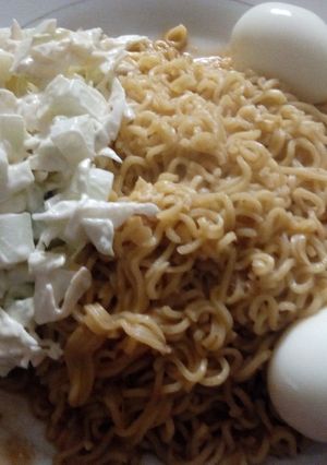A picture of Jollof noodles, egg and kukunba/ cabbage in cream.