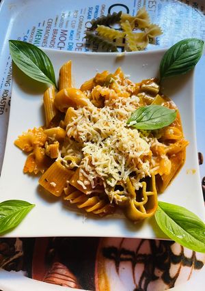 A picture of Red Pasta with Cheese and Basil.