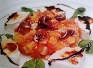 Una foto de Ensalada de tomates raf jamón y queso de cabra