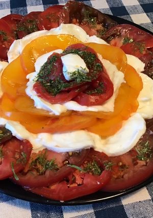 Une photo de Salade de tomates tricolores à la mozzarella di buffala et ail triquetre séché
