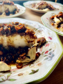 Una foto de Bacalao a la miel sobre cama de alcachofas