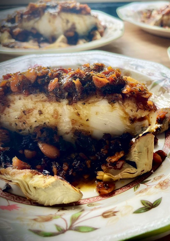 Una foto de Bacalao a la miel sobre cama de alcachofas