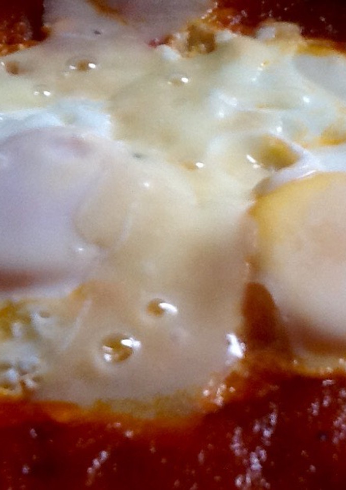 Una foto de Huevos escalfados en salsa de tomate y lascas de parmesano