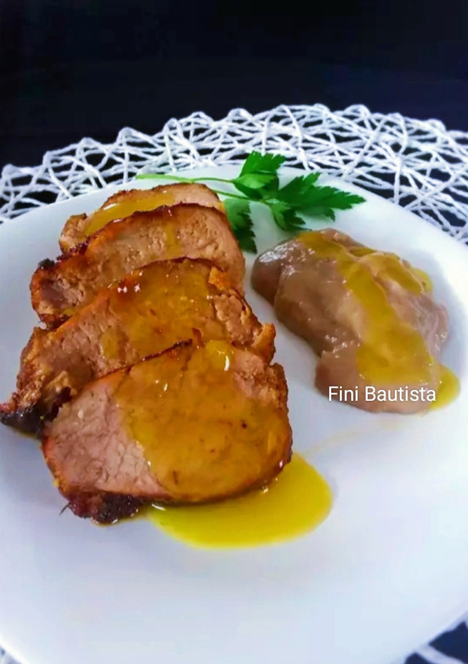 Una foto de Solomillo de cerdo con salsa de naranja y puré de plátano