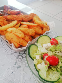 A picture of Fried chicken strips, potato wedges and a light green salad.