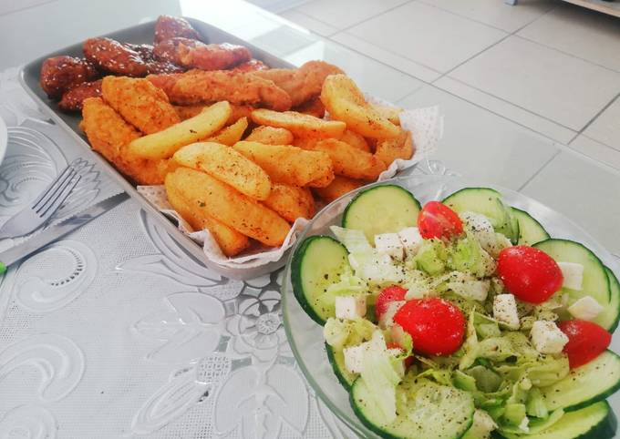 Fried chicken strips, potato wedges and a light green salad