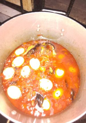 A picture of Tomato stew with smoked fish and eggs.