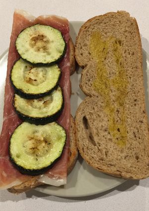 Una foto de Bocadillo de calabacín, jamón serrano, tomate triturado y orégano