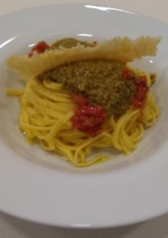 Una foto de Pasta con pesto de tomate deshidratado pistachos y almendras