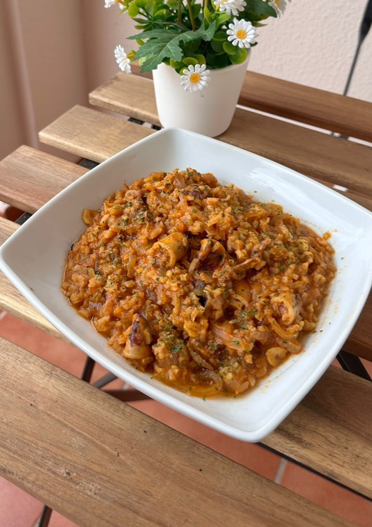 Una foto de Arroz meloso con calamares encebollados