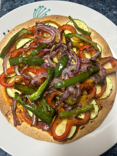Una foto de Pizza de calabacín, pimientos y cebolla de tortilla de trigo en freidora de aire