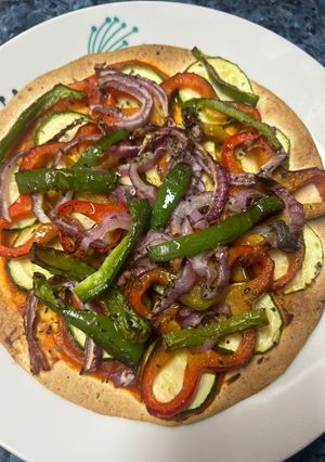 Una foto de Pizza de calabacín, pimientos y cebolla de tortilla de trigo en freidora de aire
