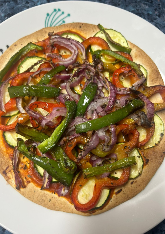 Una foto de Pizza de calabacín, pimientos y cebolla de tortilla de trigo en freidora de aire