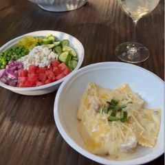 A picture of Four Cheese Ravioli with Alfredo Sauce and Grecian Salad.