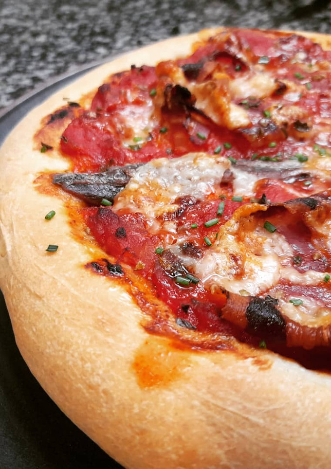 Una foto de Coca o pizza de panceta, anchoas y parmesano