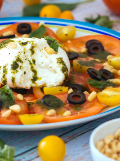 Una foto de Ensalada de tomate con burrata y aceite de albahaca