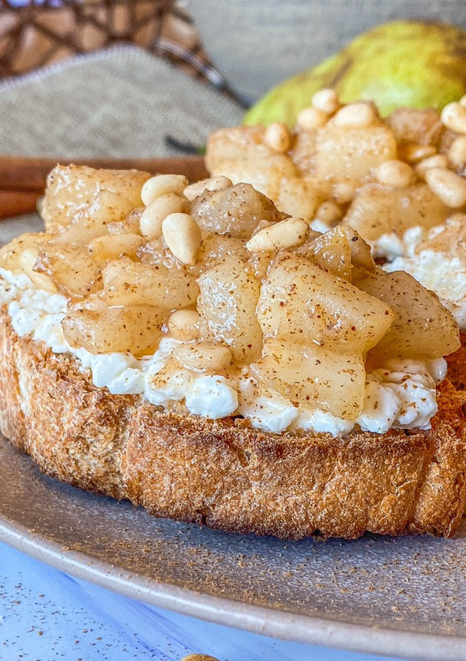 Una foto de Tostadas de requesón y pera con piñones