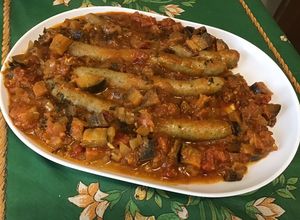 Une photo de Chipolatas au curry d'aubergine et tomates