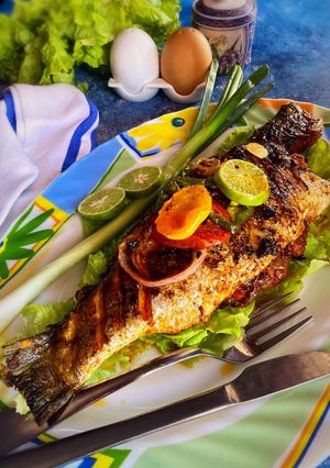A picture of Tomato herbs shrimp stuffed grilled bhetki with lemon butter sauce.