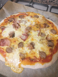 Una foto de Pizza de masa madre casera con butifarra, bacon y mozzarella 🍕