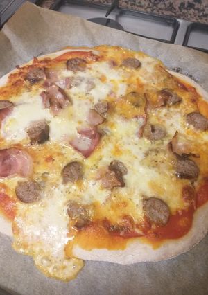 Una foto de Pizza de masa madre casera con butifarra, bacon y mozzarella 🍕