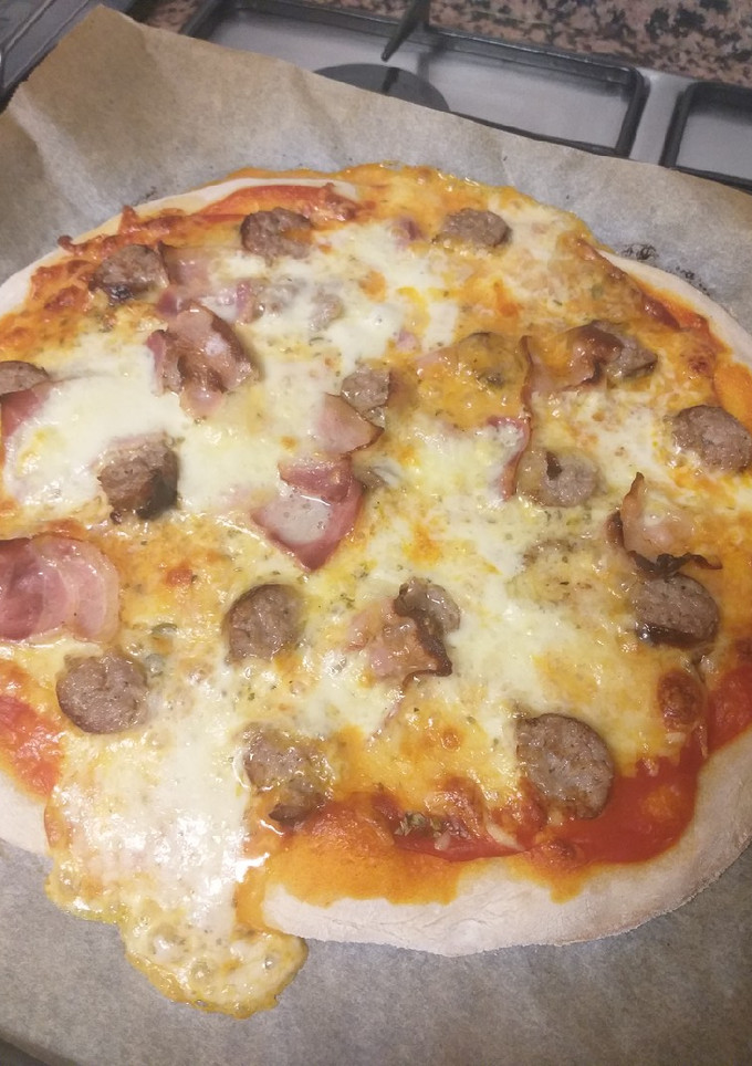 Una foto de Pizza de masa madre casera con butifarra, bacon y mozzarella 🍕