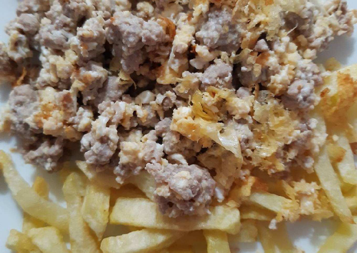 Carne picada con huevos rotos y patatas fritas