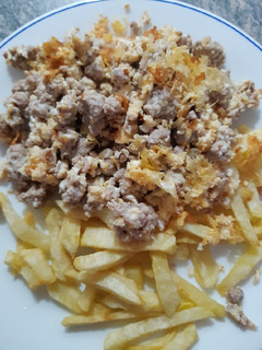 Una foto de Carne picada con huevos rotos y patatas fritas