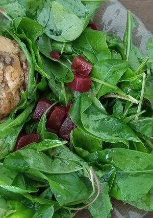 Una foto de Pollo a la cebolla con ensaladas de rúcula y remolacha