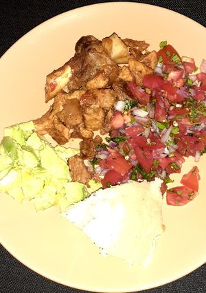 A picture of Fried pork/ugali/kachumbari/avocado.