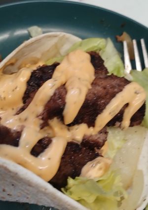 A picture of Open Steak in a wrap with lettuce & burger sauce gluten free.
