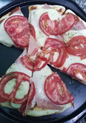 Una foto de Pizza casera. Jamón queso y tomate. Y de Cebolla y choclo