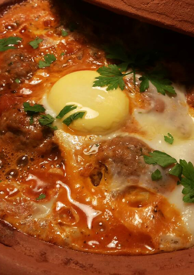 Una foto de Albóndigas con tomates especiadas y huevo