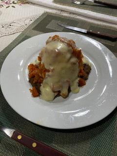 Una foto de Milanesa con puré salsa y queso