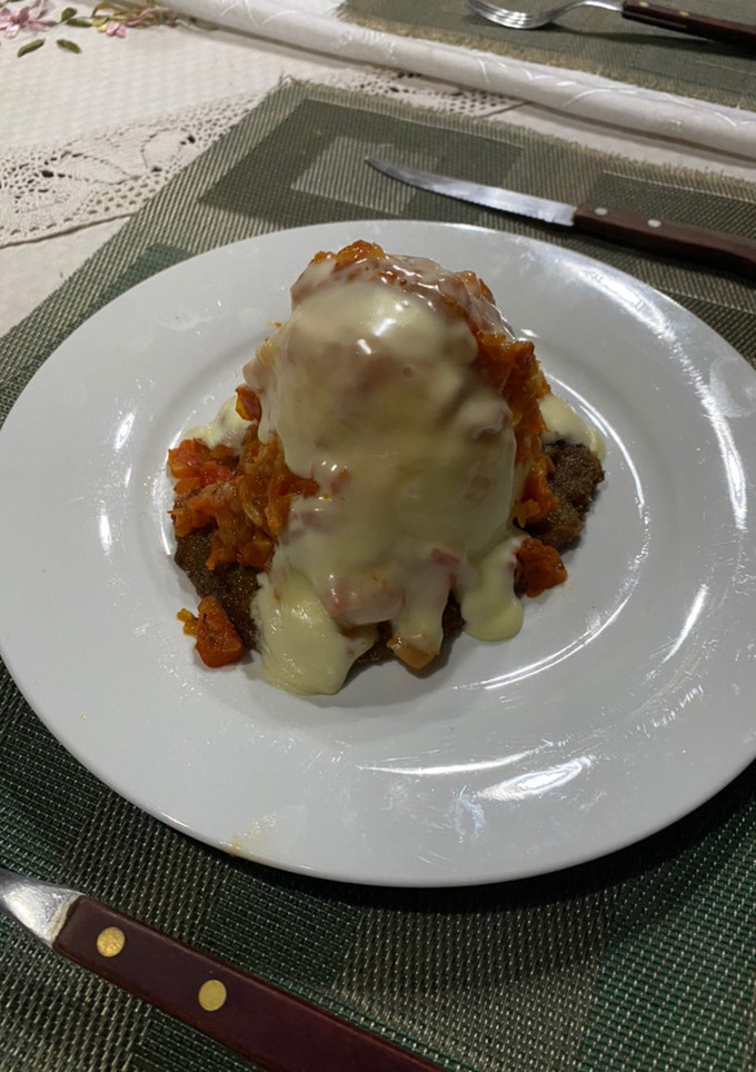 Una foto de Milanesa con puré salsa y queso