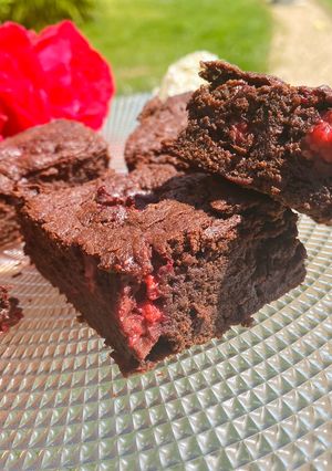 A picture of Brownies with raspberries.