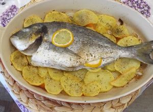 Una foto de Dorada al horno sobre lecho de patatas, cebolla y pimiento