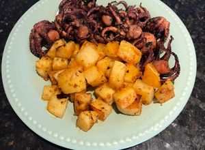 Una foto de Pulpitos de San Antonio con papas especiadas al horno