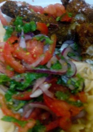 A picture of Fried chicken with kachumbari and spaghetti.