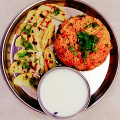 A picture of Red fried rice and potato weges.