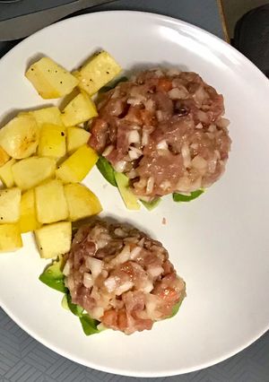 Una foto de Tartar de atún colorado con papas al horno